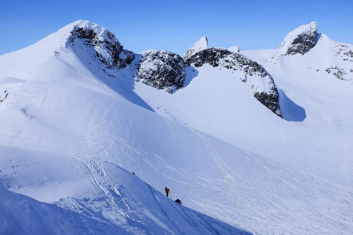 Ski tourers on the peaks around a glacier in Jotunheimen