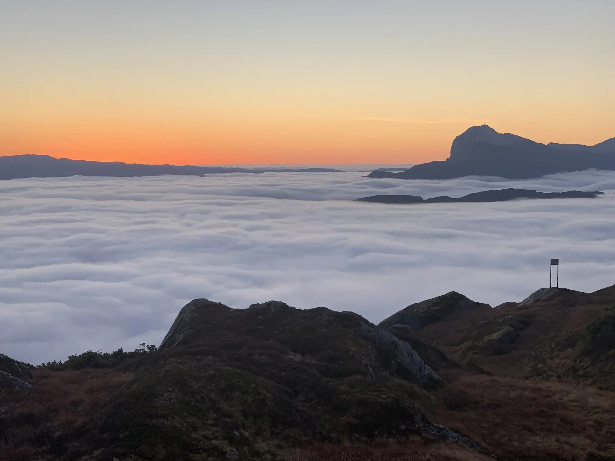 A sea of fog under the mountains at sunset in Sunnfjord